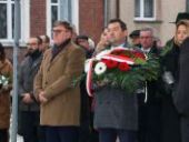 Burmistrz Wyrzyska trzyma wiązankę kwiatów.